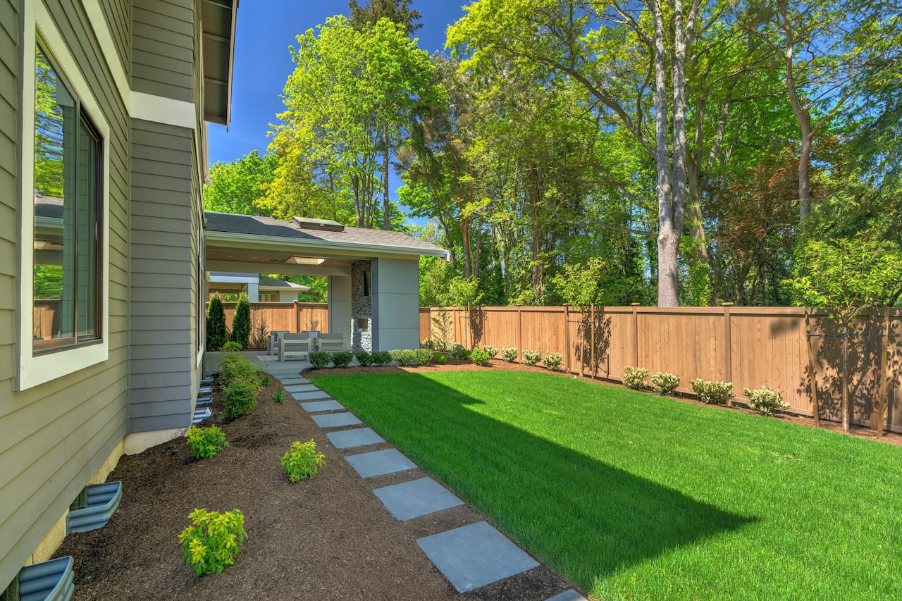 Residential landscaping with green grass and wood fence